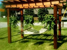 a hammock hanging from a wooden structure in the grass