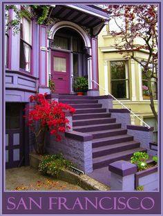 a purple house with steps leading up to the front door and flowers on the step