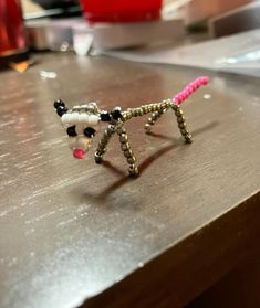 two beaded dog figurines sitting on top of a wooden table