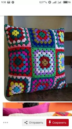 a colorful crocheted pillow sitting on top of a bed