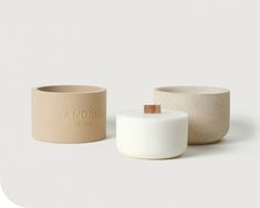 two white and beige vases sitting next to each other