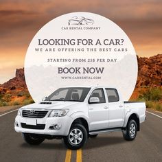 a white truck parked on the side of a road with an advertisement for car rental company