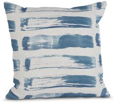 a blue and white pillow that has been painted with watercolors on the front