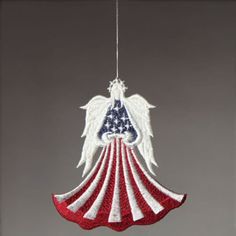 an american flag angel ornament hanging from a string in the shape of an american flag