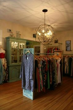 an open closet with clothes on hangers and a chandelier