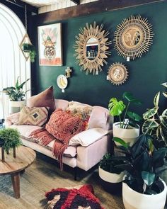 a living room filled with furniture and lots of plants on the wall next to it