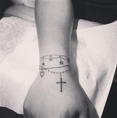 a person with a cross tattoo on their wrist