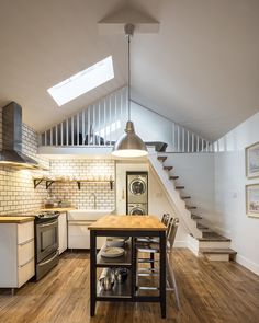 an open kitchen and dining area with stairs leading up to the second floor