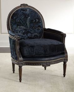 an ornate blue chair sitting on top of a carpeted floor next to a white wall