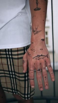 a person's hand with tattoos on it and an airplane drawn on the palm