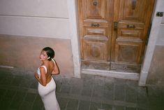 a woman standing in front of a door with her hand on her hip and looking up