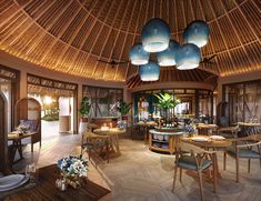 the inside of a restaurant with tables, chairs and lamps hanging from the rafters