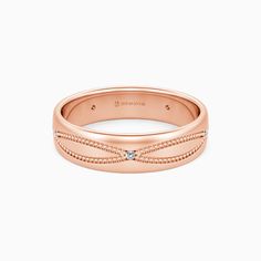 a rose gold wedding band with beaded edges and a single diamond in the center