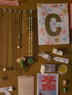 a bulletin board with various items on it including necklaces, brooches and cards