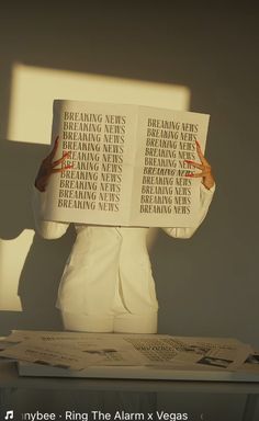 a woman holding up a book over her head with the words reading news on it