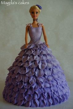 the doll is wearing a purple dress with ruffles on it's skirt