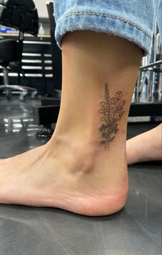 a woman's foot with a small flower tattoo on the side of her leg