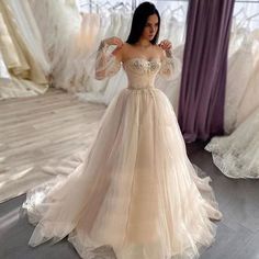 a woman standing in front of a mirror wearing a dress with long sleeves and beading