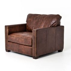 a brown leather chair sitting on top of a white floor