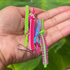 three small plastic hair clips in the palm of someone's hand with green leaves behind them