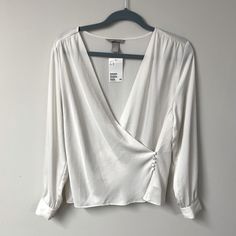 Pretty Off-White Wrap Blouse. It Ties On The Inside And Then Buttons On The Outside. Would Look Cute In The Summer With A Pair Of Jeans. New With Tags. Would Best Fit A Medium, See Measurements Below. Measurements (Laid Flat) Waist: Approx 18 In. (When Buttoned Closed) Pit To Pit: 19.4 (When Buttoned Closed) Length: 24 In Tag Size: Medium White Long Sleeve Top From H&m, H&m White Long Sleeve Top, H&m V-neck Tops For Day Out, Chic Long Sleeve H&m Blouse, Elegant H&m Shirt For Spring, Elegant Long Sleeve Tops From H&m, Elegant Long Sleeve Tops By H&m, Elegant Long Sleeve H&m Tops, H&m Long Sleeve Tops For Work