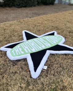 a green and black star sticker sitting on top of a brown grass covered field