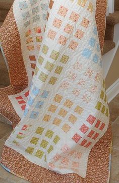 a white quilt on top of a stair case