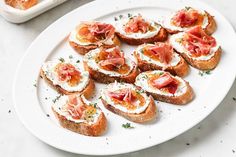 a white plate topped with toasted bread covered in toppings