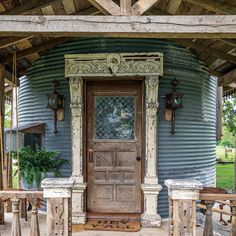 an old wooden door sits in front of a blue tin building with columns and pillars