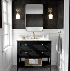 a bathroom with black and white walls, two sinks and a gold framed mirror on the wall