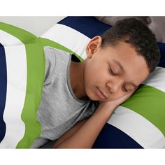 a young boy laying in bed with his head on the pillow