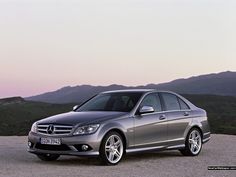 a silver car parked on top of a gravel road