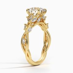 a yellow gold engagement ring with an oval diamond center surrounded by twisted vines and leaves