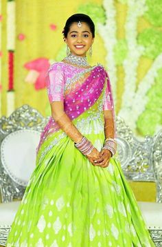 a woman in a green and pink lehenga