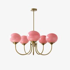 a chandelier with five pink balls hanging from it's brass finish frame