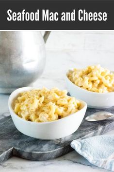 two white bowls filled with macaroni and cheese on top of a marble table