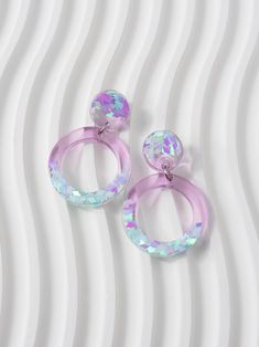 Circle shaped dangle earrings in translucent lilac purple, with colour shifting iridescent glitters in ice blue and pink tones. These are perfect for adding a pop of colour and sparkle to any outfit, and make a geometric statement wherever you go. These earrings would make a stunning gift for any pastel lover or a special treat just for you! ⚒️ These are made from resin, iridescent glitters and are attached to stainless steel hypoallergenic stud posts with butterfly backs. They measure 41 mm x 2 Clear Pierced Jewelry For Party, Glitter Party Jewelry, Iridescent Pierced Jewelry For Party, Trendy Iridescent Jewelry For Gifts, Lavender Drop Earrings For Party, Pierced Iridescent Jewelry For Party, Pierced Circular Party Earrings, Trendy Handmade Clear Jewelry, Iridescent Pierced Drop Earrings