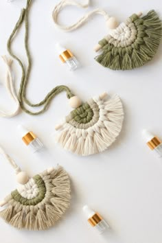 three pieces of woven and tasseled jewelry laid out on a white table top