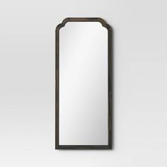 a large mirror hanging on the wall next to a white wall with a black frame