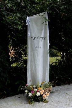 a white wedding banner with flowers on it