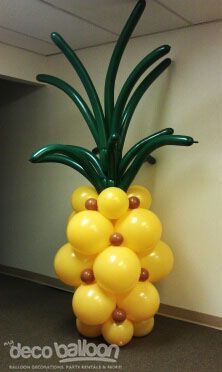 a balloon sculpture made to look like a pineapple is on display in an office cubicle