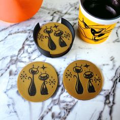 three coasters sitting on top of a marble table next to a cup of coffee