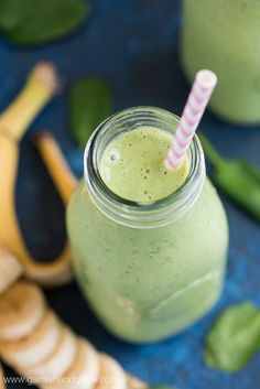 a green smoothie in a mason jar with a striped straw