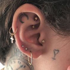 a close up of a person with piercings on their ear