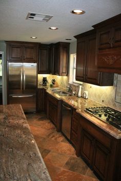 a kitchen with granite counter tops and stainless steel refrigerator freezer next to an oven