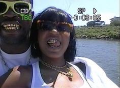 a man and woman wearing sunglasses are posing for a photo in front of the water