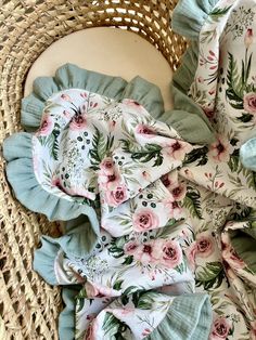 a basket with flowers on it and some fabric in the middle, sitting next to a wicker chair