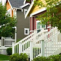 a row of houses with white railings and trees