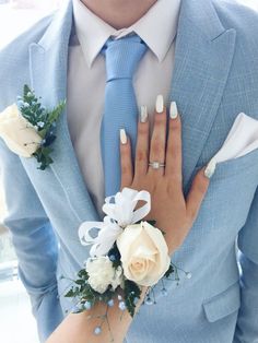 a man wearing a blue suit and tie with white flowers on his lapel flower