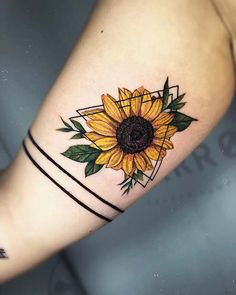 a sunflower tattoo on the left arm